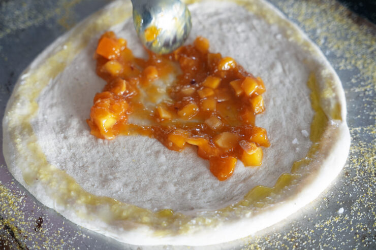 Adding mango chutney to the pizza base